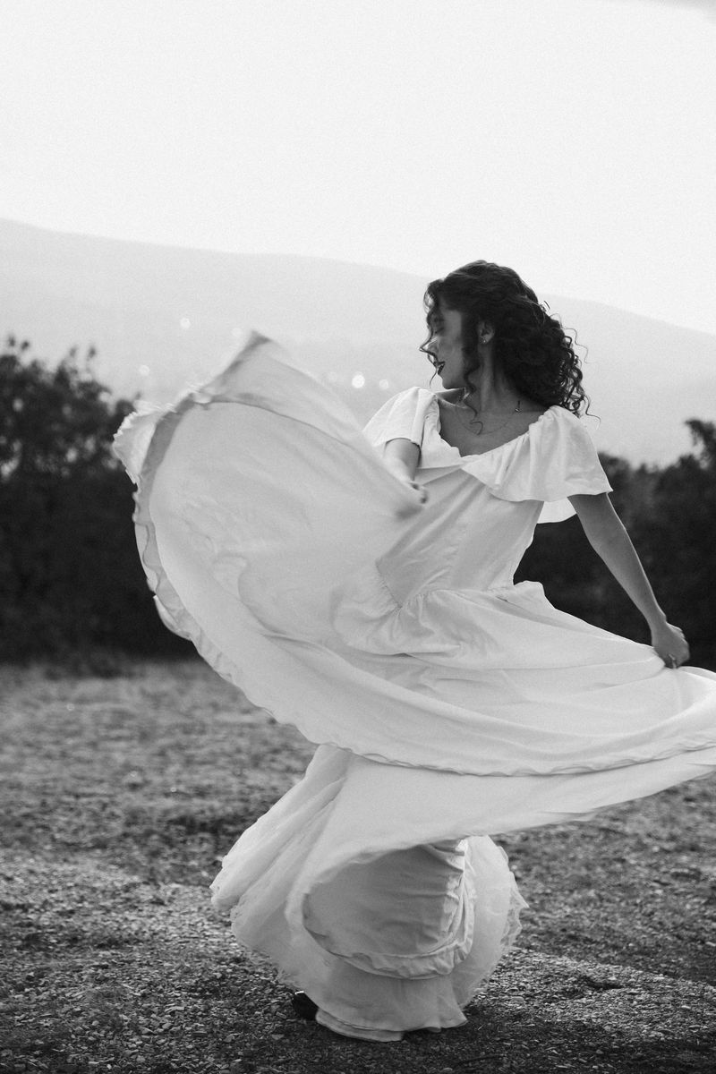 Black and white: a woman spinning, her dress flying out in a wide circle