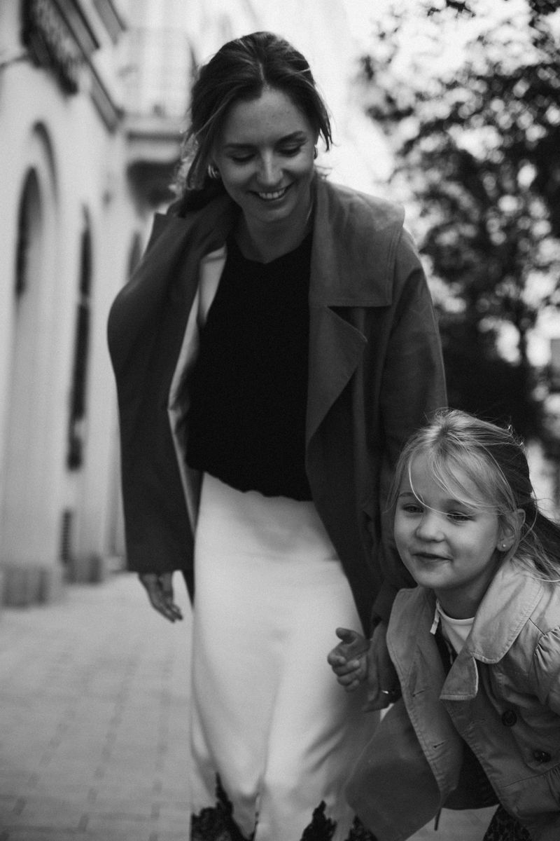 Black and white: a mother walks with her daughter, both smiling
